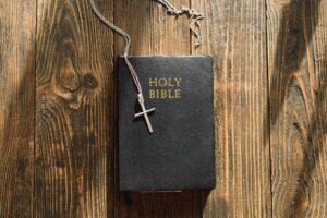Bible and cross on a wood background. Study Bible worship concept.